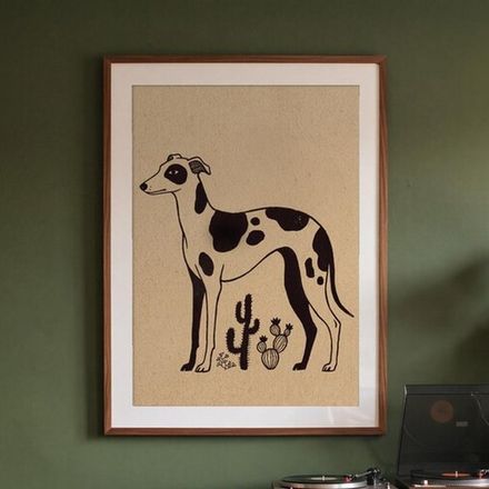 Black and white whippet print framed on a green wall